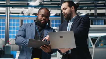 Team of diverse analysts consultants reviewing data and checklists in a high tech solar panel plant, ensuring manufacturing process meets sustainable energy and innovation standards. Camera A. - Powered by Adobe