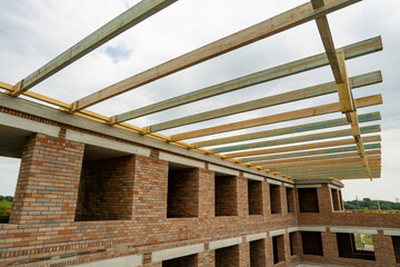 Brick apartment building under construction, wooden roof structure