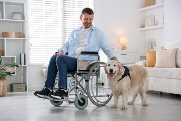 Man in wheelchair with his service dog at home