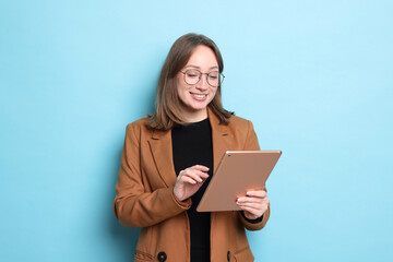 Fototapeta premium Woman with modern tablet on light blue background