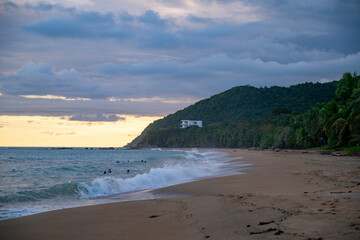 Sunset on the beach with rocky coastal cliffs. 