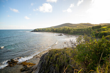 An aerial view of the beach and mountains during sunset. 