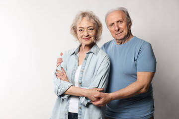 Portrait of lovely senior couple on white background, space for text