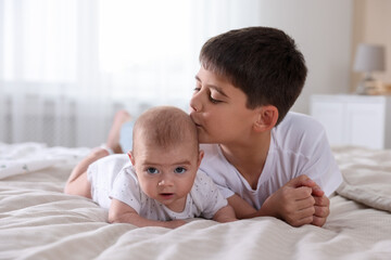 Cute little brothers on bed at home