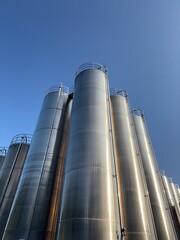 Large stack of metal tanks with a clear blue sky in the background
