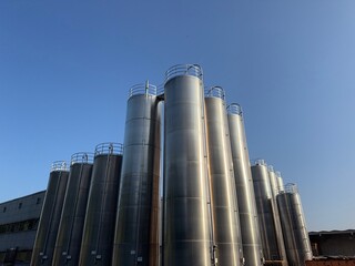 Large industrial building with many tall tanks