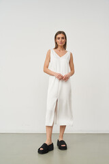 Elegant fashion model showcasing stylish white dress in modern studio setting