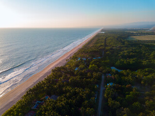 Aerial coastal view of ample beach shore in La Libertad, El Salvador during a tranquil afternoon.