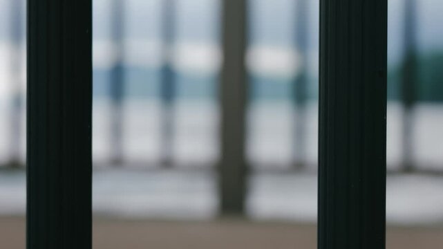 海上デッキのフェンス越しに見る陰鬱な空と海