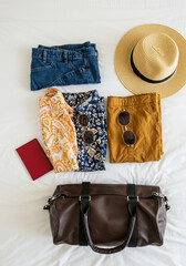Travel Essentials on Hotel Bed with Duffle Bag