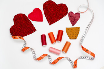 Heart-shaped fabric appliques or applications, accompanied by an arrangement of red threads and an...