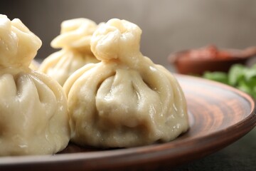 Delicious cooked khinkali served on table, closeup