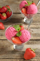 Tasty sorbet with strawberries and mint served on wooden table, closeup