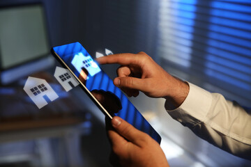 Real estate agent touching house icon on tablet screen indoors, closeup. Search for apartment