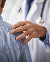 A poignant close-up of a senior patient's hand resting gently on a doctor's shoulder, conveying a moment of compassion, trust, and reassurance in a healthcare setting