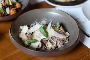 Elegant plate of assorted cheeses mushrooms and fresh herbs beautifully presented for a luxurious hotel dining experience