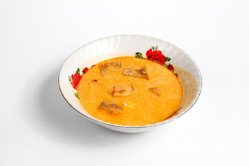 fried sambal dish filled with potatoes mixed with coconut milk and spicy krecek served in a ceramic bowl ,isolated on white background