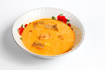 fried sambal dish filled with potatoes mixed with coconut milk and spicy krecek served in a ceramic bowl ,isolated on white background