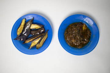 A simple yet delicious dish of fried eggplant slices with traditional chili sauce, served on a blue...