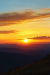 Obraz premium Vibrant sunset over layered mountain ranges with golden and orange skies and scattered clouds creating a peaceful and warm atmosphere