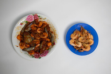 Fried prawns and prawns in red chili sauce, others served plain, ready to cook or eat.