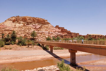 Scenic views of tourists crossing the bridge to Ait Benhaddou, central Morocco