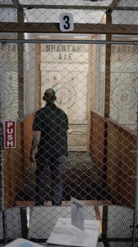 Slow Motion Wide Shot Of Man Throwing An Axe At The Target At An Axe Throwing Lounge 