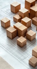 Light-colored wooden blocks arranged on architectural blueprints (1)