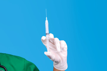 Gloved Hand of Medical Professional Holding a Syringe for Injection Against Blue Background