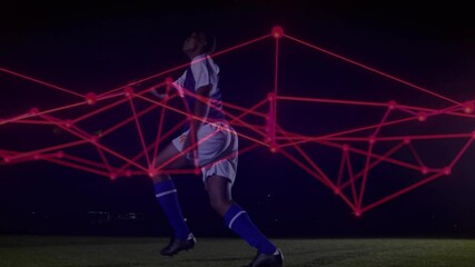 Soccer player receiving ball then striking it on night field, red network overlaying sports tech - Powered by Adobe