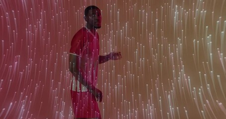 Incoming ball motivating soccer player leaning and executing bicycle kick with lights showing tech