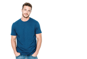 A young man in a casual blue t-shirt stands confidently against a plain white background. showcasing a relaxed pose with hands in pockets. ideal for lifestyle or fashion stock imagery