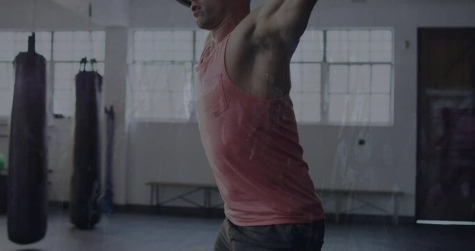 Male gymgoer gripping barbell executing overhead squat in gym while static overlay flickering