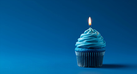 Single Blue Cupcake with Lit Candle on Blue Background
