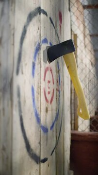 Slow Motion Axe Throw Hitting and Sticking Into Wooden Target at Indoor Throwing Lounge