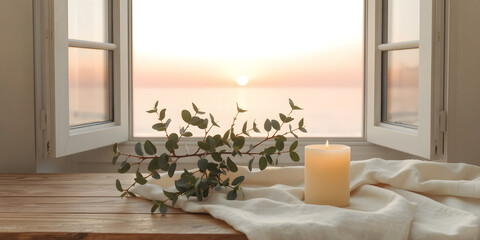 Pale Yellow Beeswax Candle with Eucalyptus and Soft Fabric. Pale Pink Sunset Over Low Flat Sea