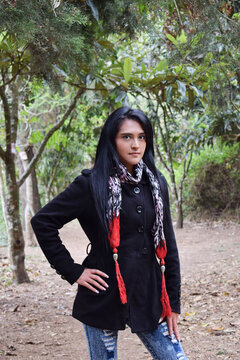 Moda de invierno, mujer joven Guatemalteca posando para la c&aacute;mara con un abrigo negro, pantal&oacute;n azul y una bufanda. Concepto de moda, belleza y estilo.