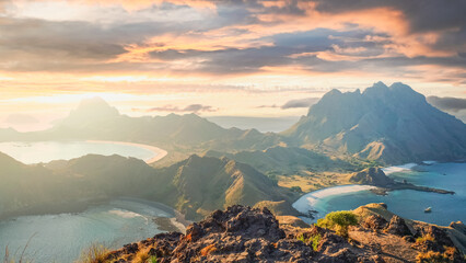 Grassy cliff tops with ocean and mountain backdrop at Padar Island, Komodo National Park, Indonesia. Summer adventure and travel photo.