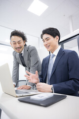 打ち合わせをするスーツを着たビジネスマン2人の動画　新人さんに教える上司縦