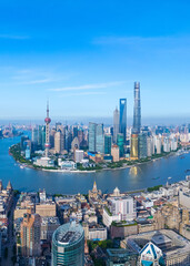 Aerial view of Shanghai skyline and winding river on sunny day.