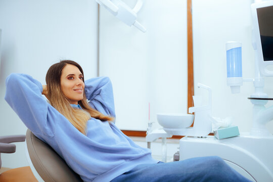 Happy Patient Sitting Relaxed in the Dental Office. Smiling woman takes preventive care of her oral health 
