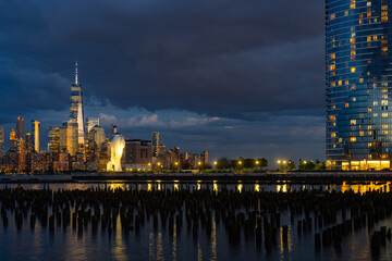 Obraz premium New York City at night. NYC cityscape with skyscrapers. Panoramic of New York City skyline on dusk. Manhattan skyline. New York and Hudson River. Downtown NYC. New York skyscrapers on sunset.