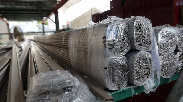 Bundles of synthetic Bohio building materials wrapped in plastic stored inside a warehouse