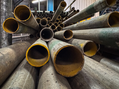 A pile of rusty pipes in an old factory used for industrial purposes and this photo for backdrop