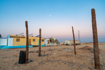 This image captures abandoned homes in the desert near Aswan, Egypt, at dawn. The serene sky and desolate landscape create a striking contrast, highlighting the beauty and isolation of the area.