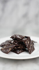 Crispy brownies arranged on a glass jar and white ceramic plate with a white marble background....