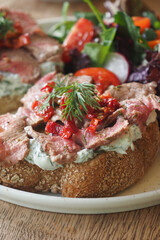 Delicious open-faced sandwich with beef and fresh salad
