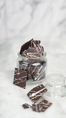 Crispy brownies arranged on a glass jar and white ceramic plate with a white marble background. isolate objects and background