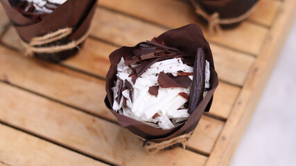catherine chocolate cake wrapped in brown cake paper and tied with hemp rope, arranged on a hollow...