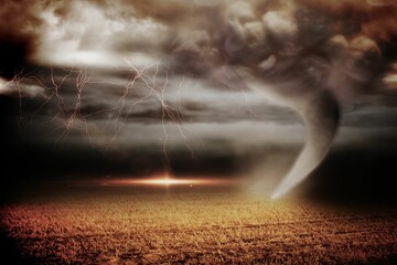Stormy sky with tornado over field